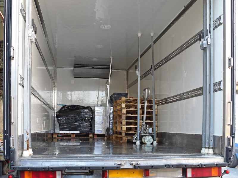 Interior de un camión refrigerado con tarimas y equipo de carga como parte de la cadena de frío.
