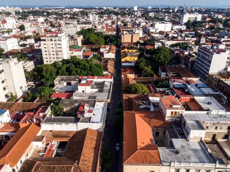 Vista aérea de ciudad con contrastes de infraestructura, reflejando el impacto desigual del crecimiento urbano.